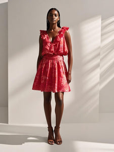 Woman wearing a red dress with ruffled sleeves against a white background