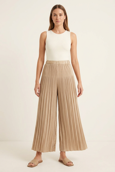 Model wearing champagne-beige pleated wide-leg pants with an ivory top