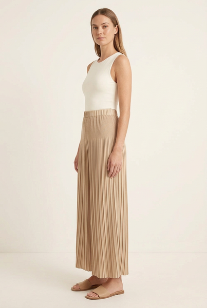 Side view of model wearing champagne-beige pleated wide-leg pants with an ivory top