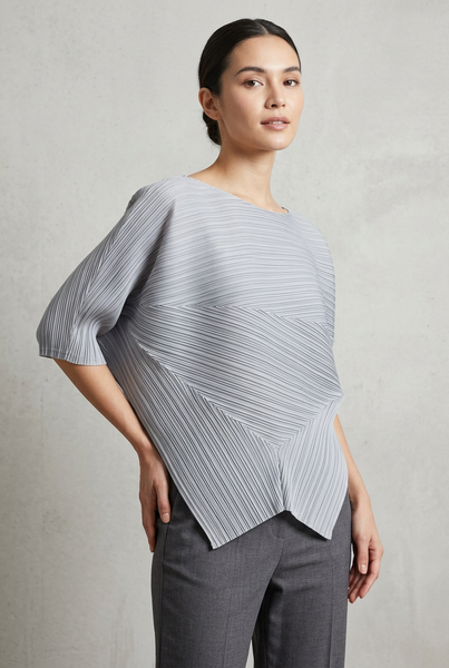 Model in a three-quarter pose wearing the grey pleated top