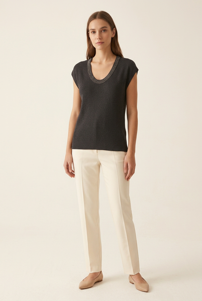 Full-body model wearing charcoal shimmer trim scoop neck knit top with cream trousers