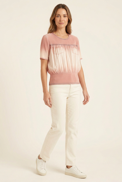 Model in a three-quarter pose wearing a short pink ombre pleated top with ivory trousers