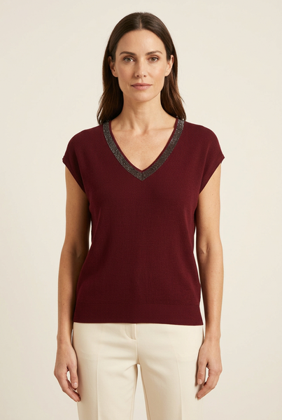 Model wearing maroon shimmer trim scoop neck knit top with cream trousers