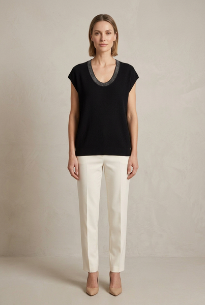 Full-body model wearing the black shimmer scoop-neck top with ivory trousers and neutral heels