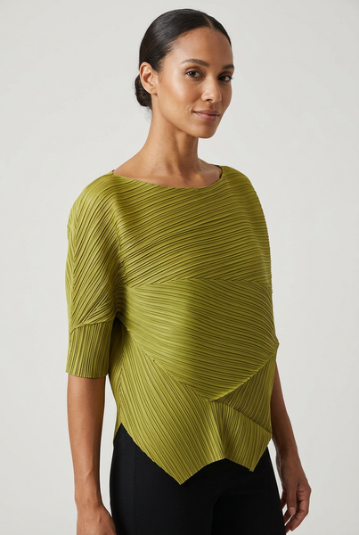 Model in a three-quarter pose wearing the green irregular pattern pleated top